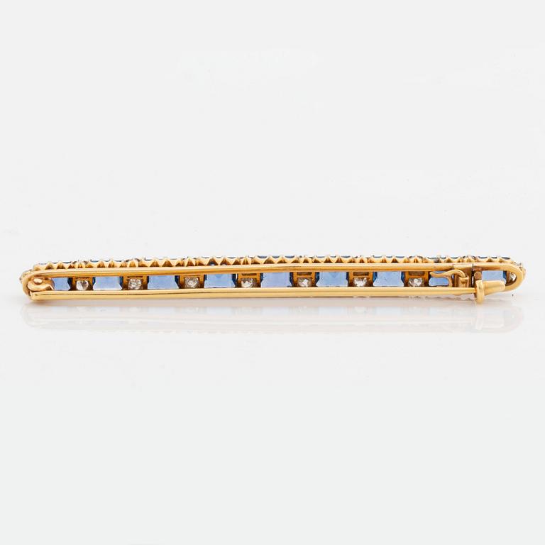 An 18K gold brooch set with step-cut sapphires and old-cut diamonds.