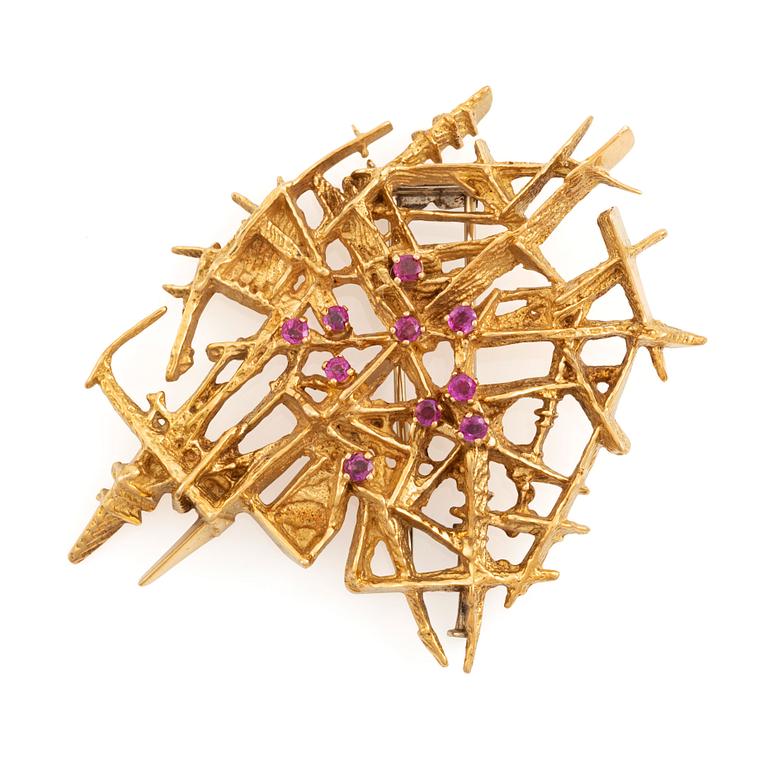 An 18K gold brooch set with faceted rubies.