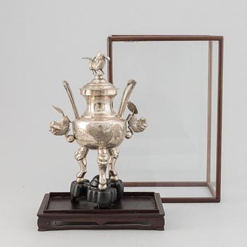 A Chinese metal incense burner in a wooden display case 20th century.