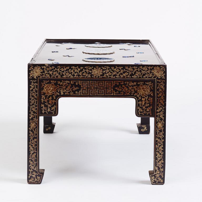 A Chinese black lacquered table with porcelain placques, presumably first half of the 20th century.