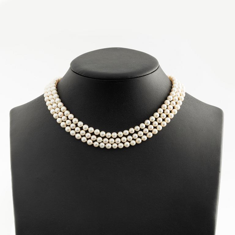 Necklace, three-stranded with cultured pearls, clasp in white gold with sapphires and small diamonds.