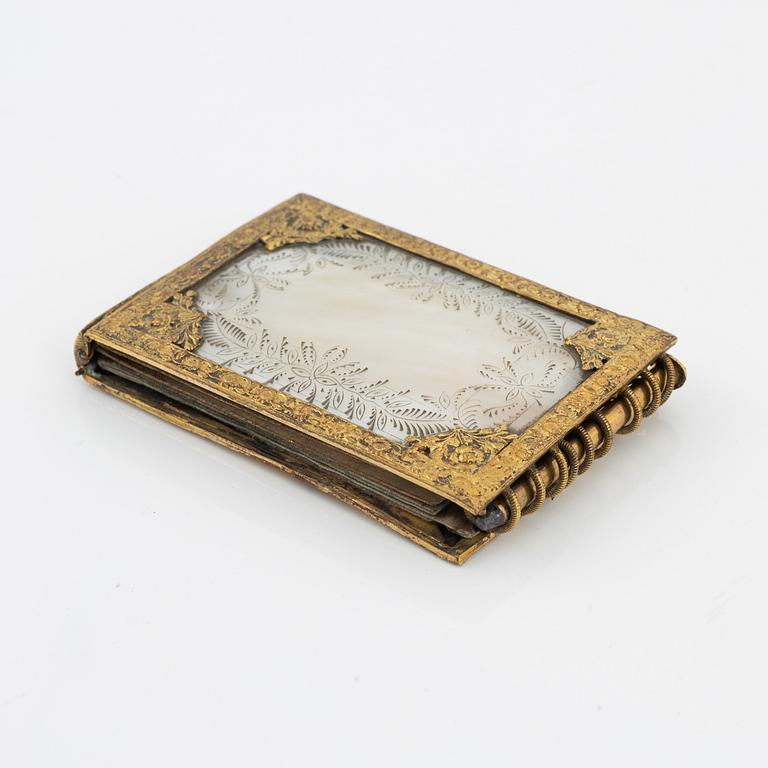 A gilt metal and mother-of-pearl pocket calendar, early 20th Century.