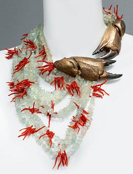 A Kristian Nilsson necklace with a gilded silver clasp and twelwe strands of coral, quartz and peridot.