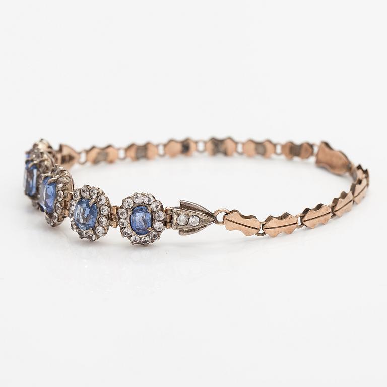 A 4-8K gold bracelet with light blue and white sapphires.