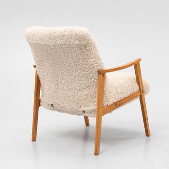 An oak easy chair with sheepskin upholstery. second part of the 20th Century.