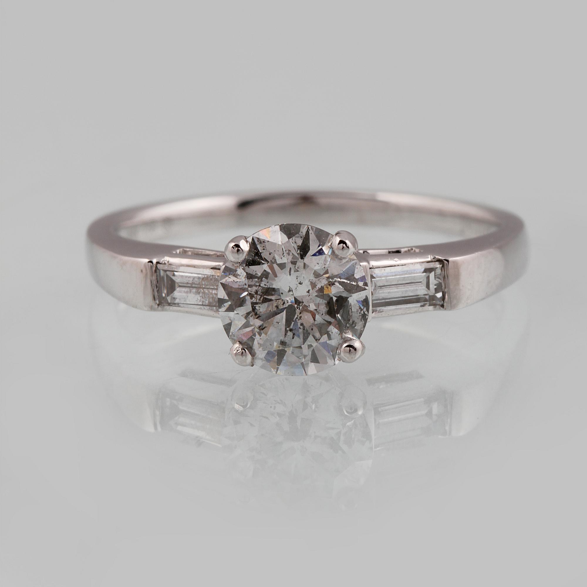 RING, 18K vitguld med briljantslipad diamant ca 1.05 ct samt 2 baguettslipade diamanter ca 0.17 ct. Vikt 3,2 gram.