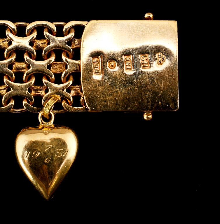 ARMBAND, 18k guld, länk med en berlock, Stockholm, 1958. Vikt 40 g.