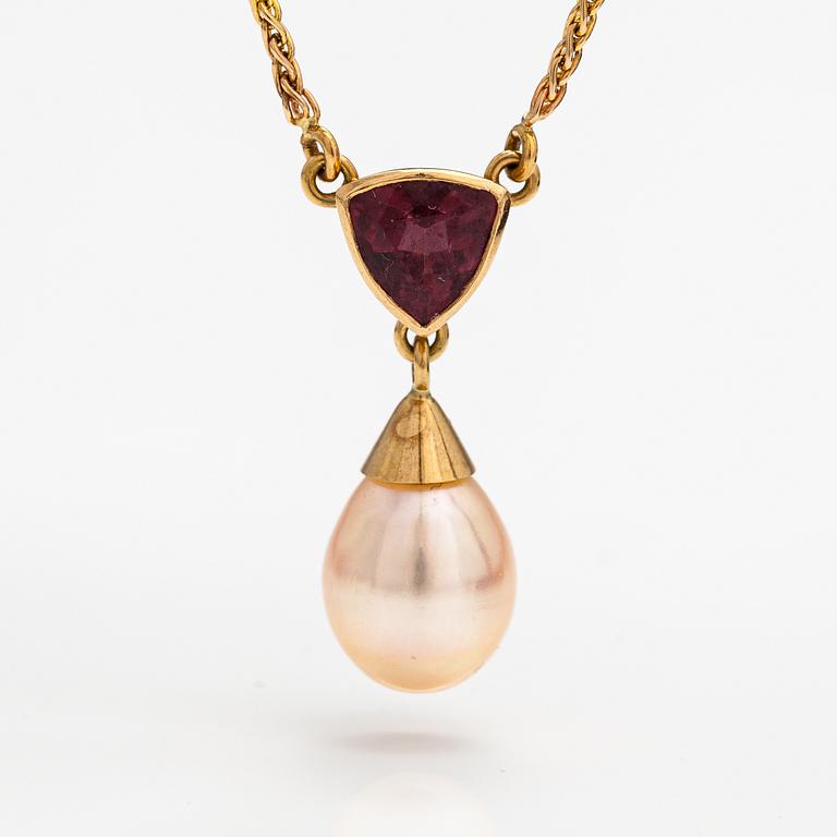 A 14K gold necklace with a tourmaline and cultured pearl.