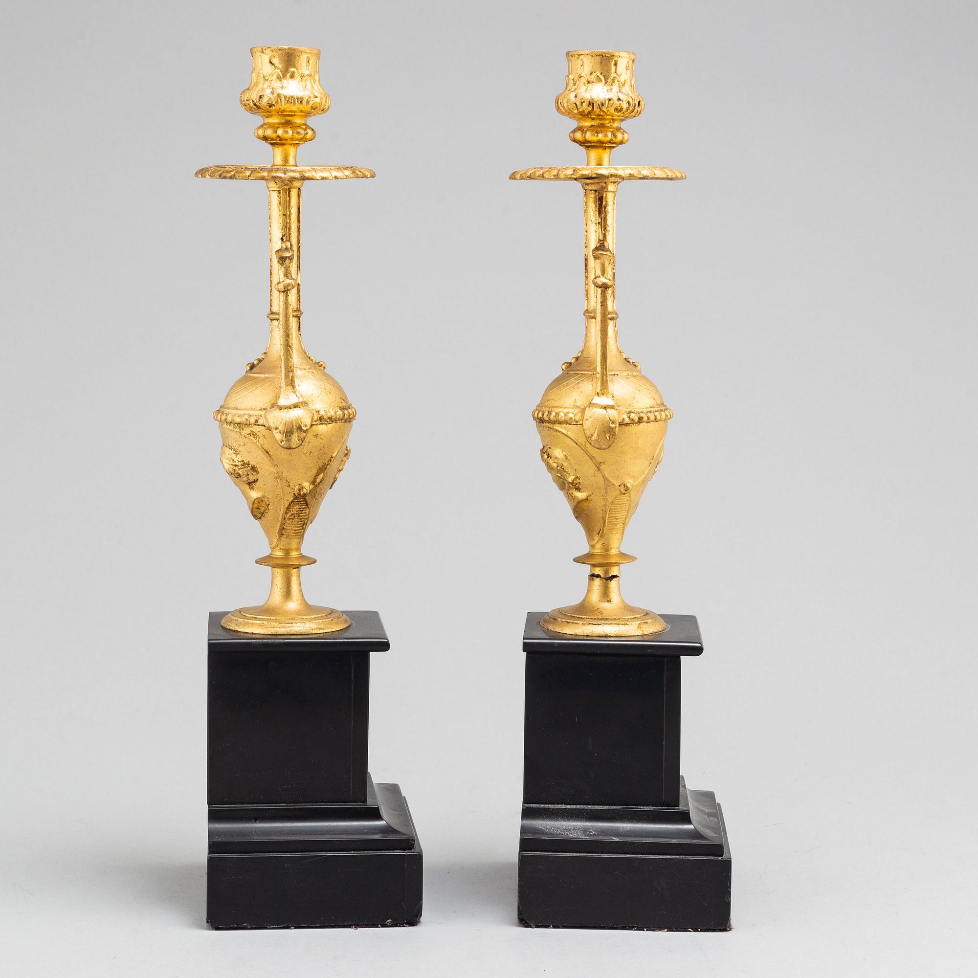 A late 19th century table clock and a pair of candlesticks.