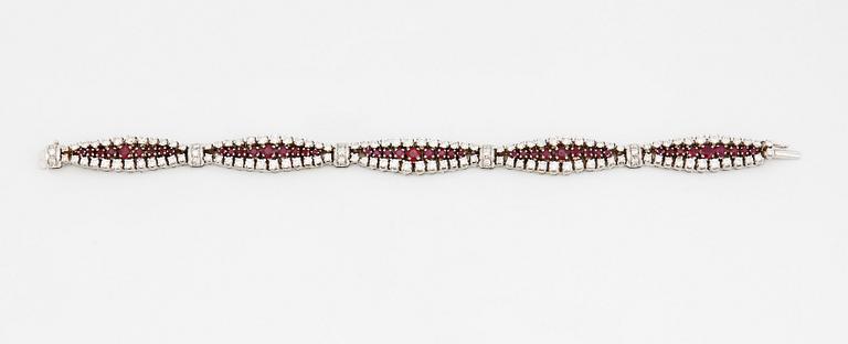 An 18K white gold bracelet set with rubies and round brilliant-cut diamonds.