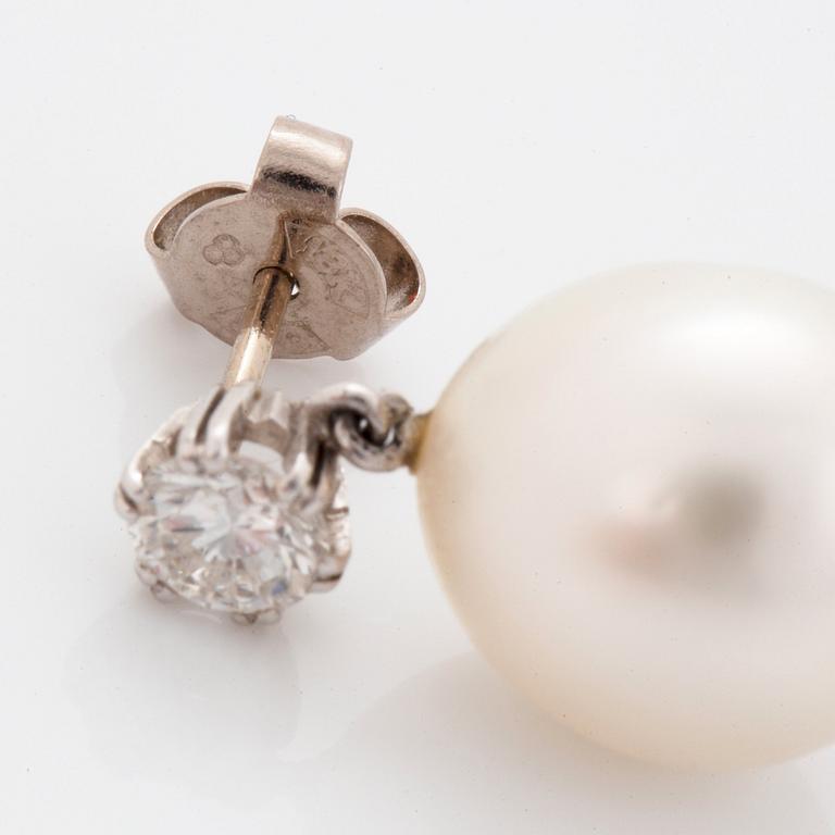 A pair of 18K white gold earrings set with round brilliant-cut diamonds and cultured pearls.