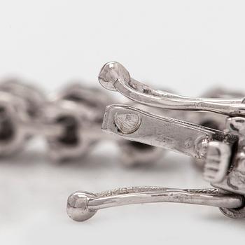 An 18K white gold tennis bracelet, with brilliant-cut diamonds.
