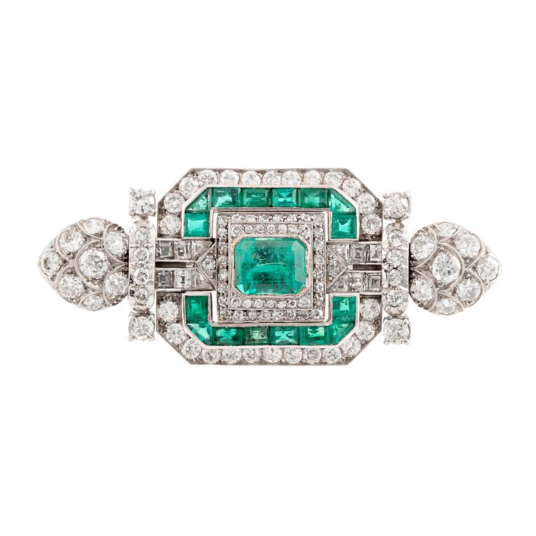 An 18K white gold Marchak art deco brooch set with step-cut emeralds.