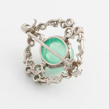 A platinum brooch with a cabochon-cut emerald.