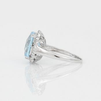 RING, 18K vitguld med chequerslipad blå topas, ca 5,23 ct, diamanter tot ca 0,20 ct. Vikt ca 4,17 g.
