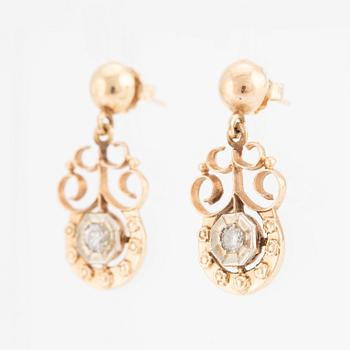 A pair of earrings in 14K gold set with round brilliant-cut diamonds.