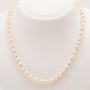 A necklace of cultured pearls with an 18K white gold lock set with single cut diamonds.