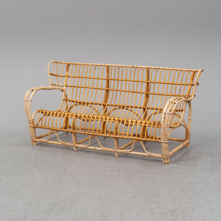 A rattan and glass table and a rattan sofa, second half of the 20th century.