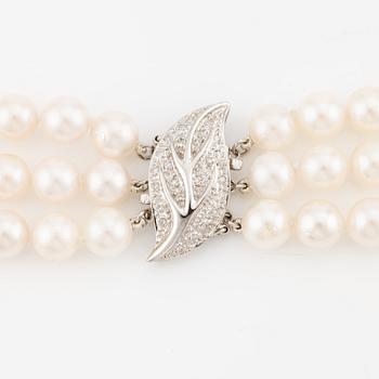 Necklace, pearls, three strands, clasp in 14K white gold with small diamonds.