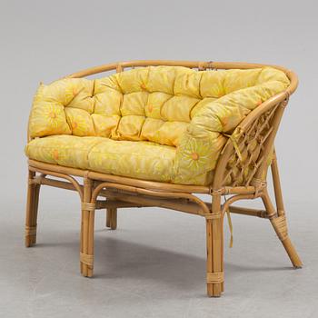 A 1970s four piece set of rattan garden furniture.