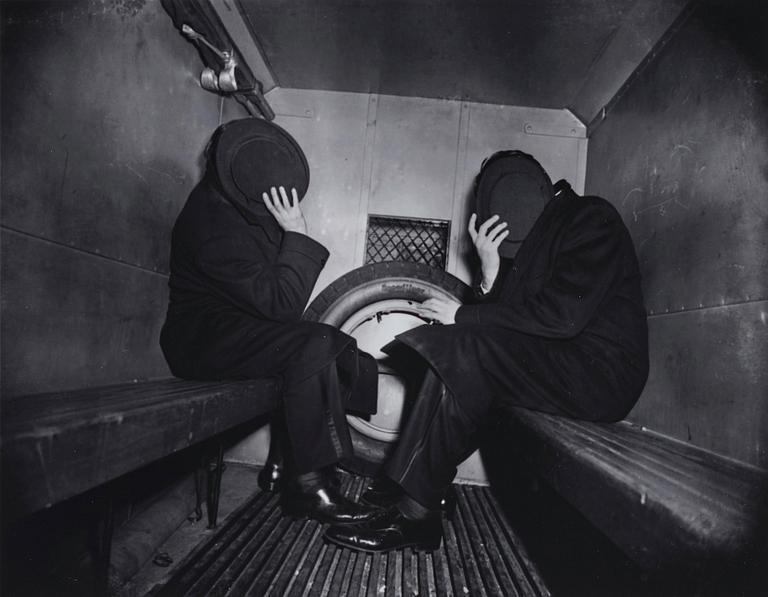 Weegee, "Charles Sodokoff and Arthur Webber using their top hats to hider their faces, New York, January 26 1942".