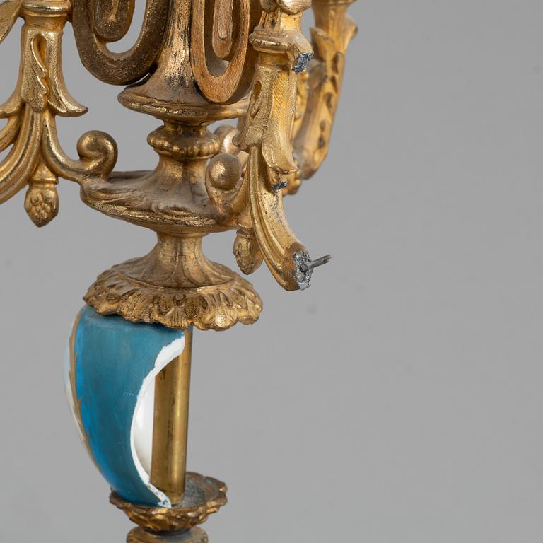 A Louis XVI style mantel clock and a pair of candelabra, circa 1900.