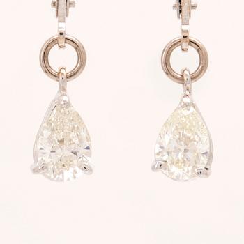 A pair of 18K white gold earrings set with pear cut diamonds.