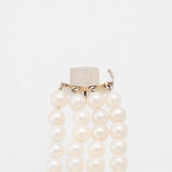 Bracelet 4-row with cultured pearls, round brilliant-cut and baguette-cut diamonds, and clasp in 14K white gold.