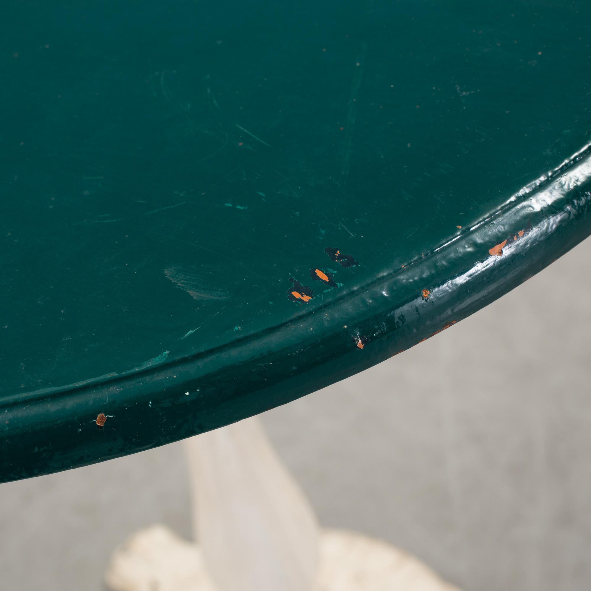 A pair of cast iron chais with wooden seats and a cast iron table, early 20th century.