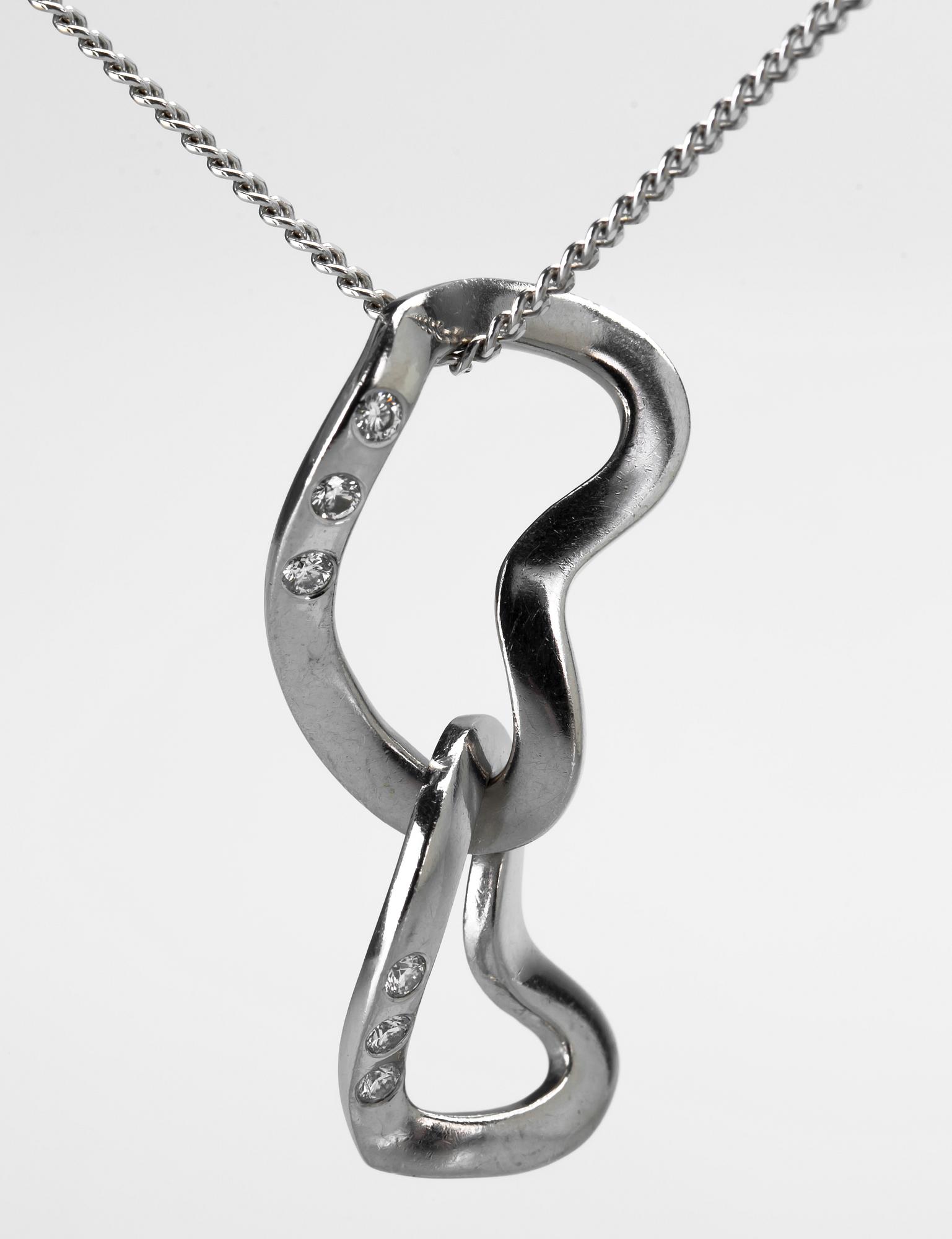 HÄNGE SAMT KEDJA, "Interlocking hearts", Regitze Overgaard för Georg Jensen, 18 k vitguld med diamanter. Vikt ca 7,5 g.