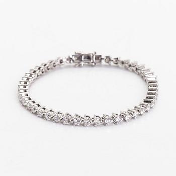 An 18K white gold tennis bracelet, with brilliant-cut diamonds.