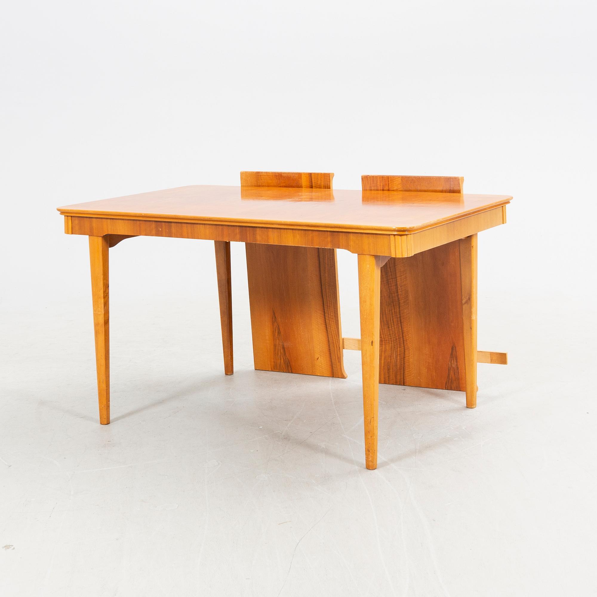 A 1940s mahogany and walnut dining table.