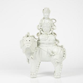 A large blanc de chine sculpture of a boddhisattva seated on a mythical creature, China, 20th Century.