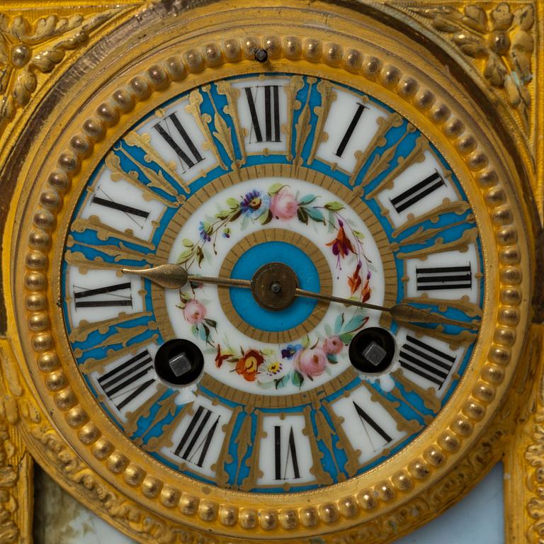 A French Louis XVI-style mantel clock and a pair of candelabra, late 19th Century.