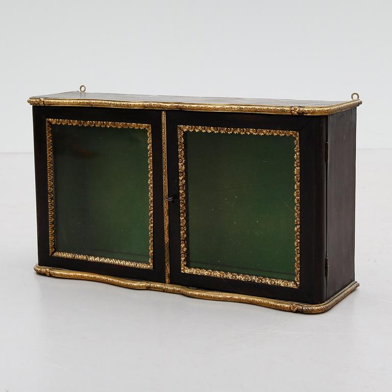 VÄGGVITRINSKÅP, omkring år 1900.