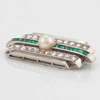 A platinum brooch set with old- and rose-cut diamonds, faceted emeralds and a pearl.