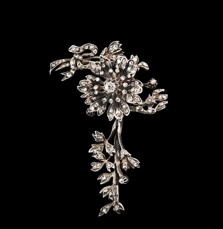 BROSCH, mittstenen antikslipad diamant ca 0.35 ct. 118 små rosenslipade diamanter. Silver på 18K guld.
