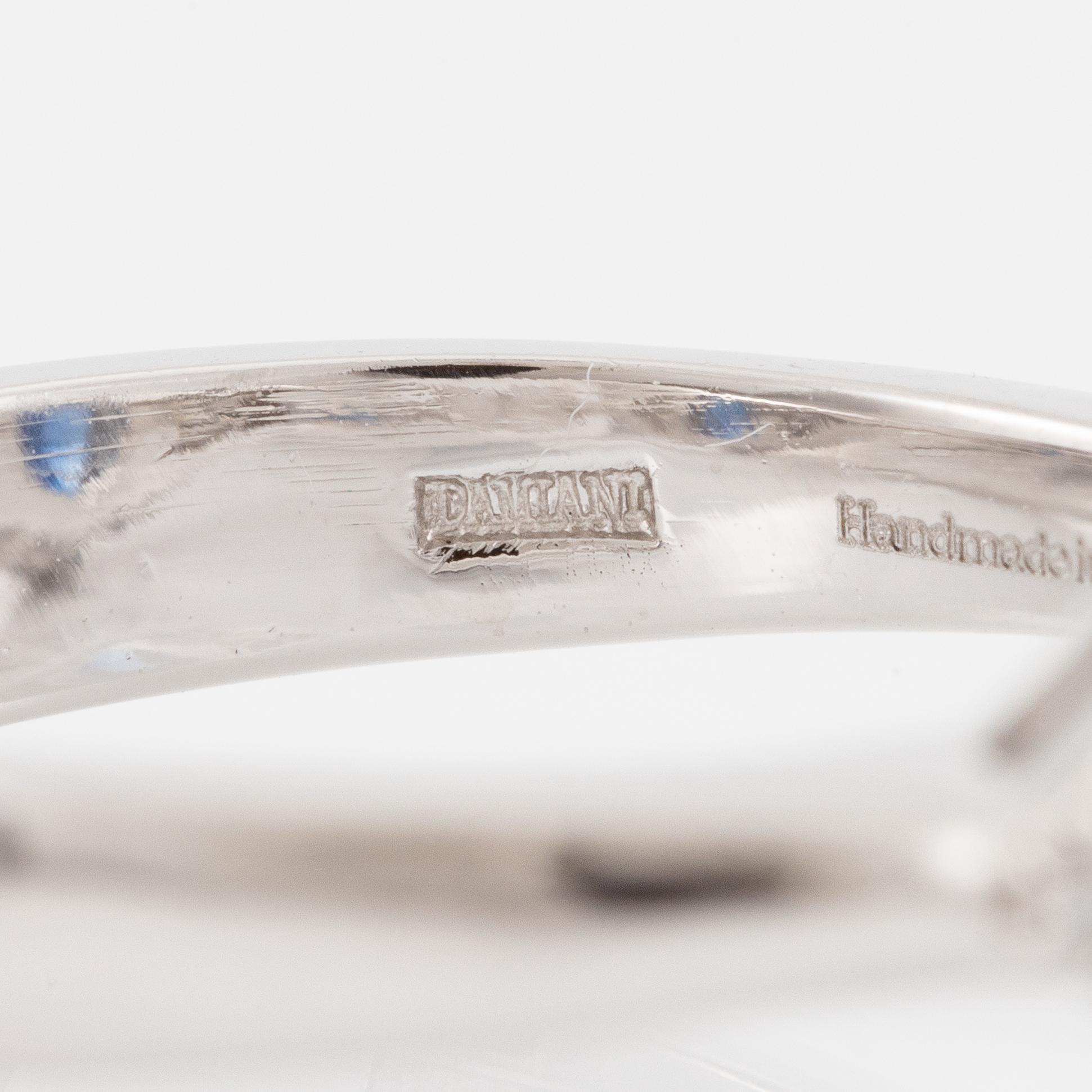 Damiani ring platina med en fasettslipad safir samt triangulära- och runda briljantslipade diamanter.
