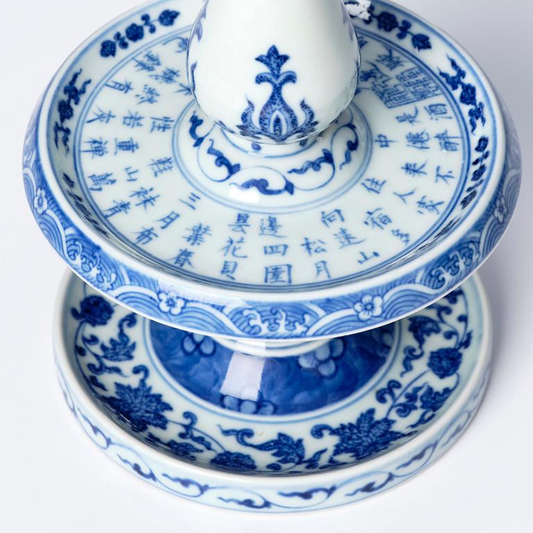 A pair of blue and white pricket candle sticks, with a poem, Qing dynasty with a Qianlong mark and of the period.