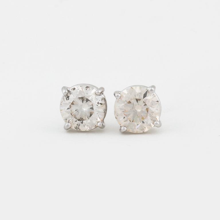 A pair of brilliant cut diamond earrings.