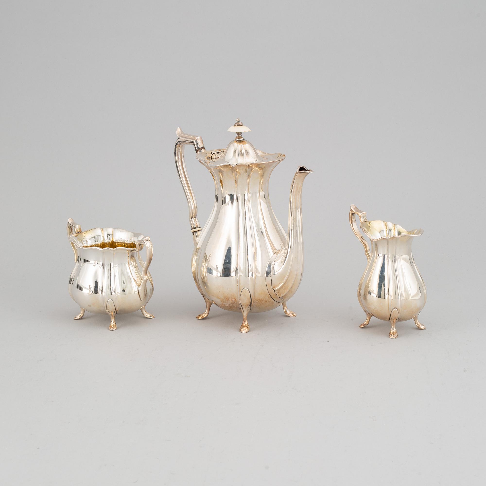 A silver coffee pot, creamer and sugar bowl and a pair of candlesticks, GAB Stockholm 1946 and Dacapo Lidköping 1988.