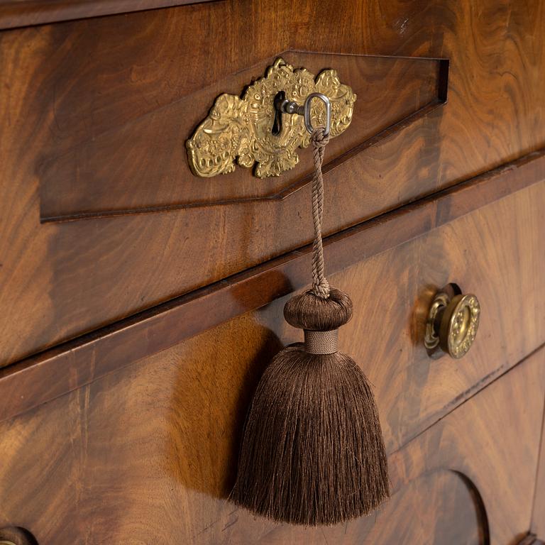 A mahogany veneered Empire chest of drawers, first half of the 20th Century.