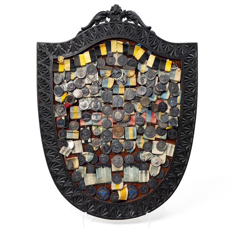 Idrottsmedaljer på märkessköld. Delvis silver. Sverige 1900-talets första hälft.