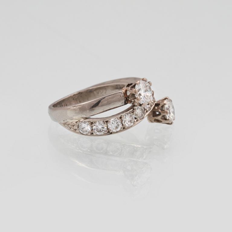 RING, 18K guld med 2 större briljantslipade diamanter ca 0.60 ct vardera samt 11 st mindre totalt ca 1.10 ct. Vikt 7,3 g.
