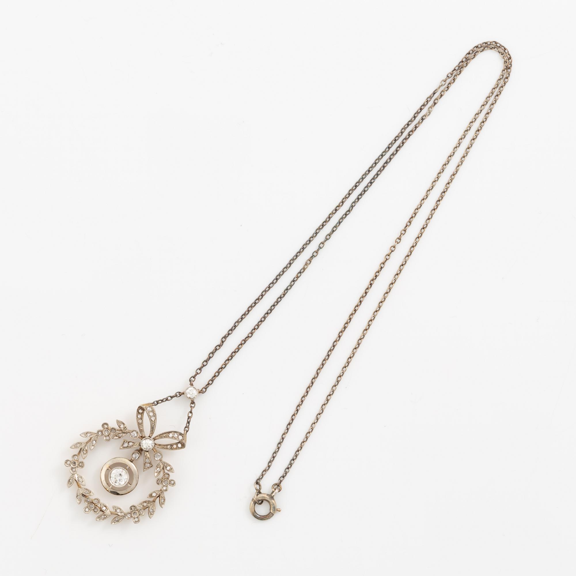 Hängsmycke 18K guld och silver i form av rosettkrans med gammal-och rosenslipade diamanter, omkring sekelskiftet 1900.