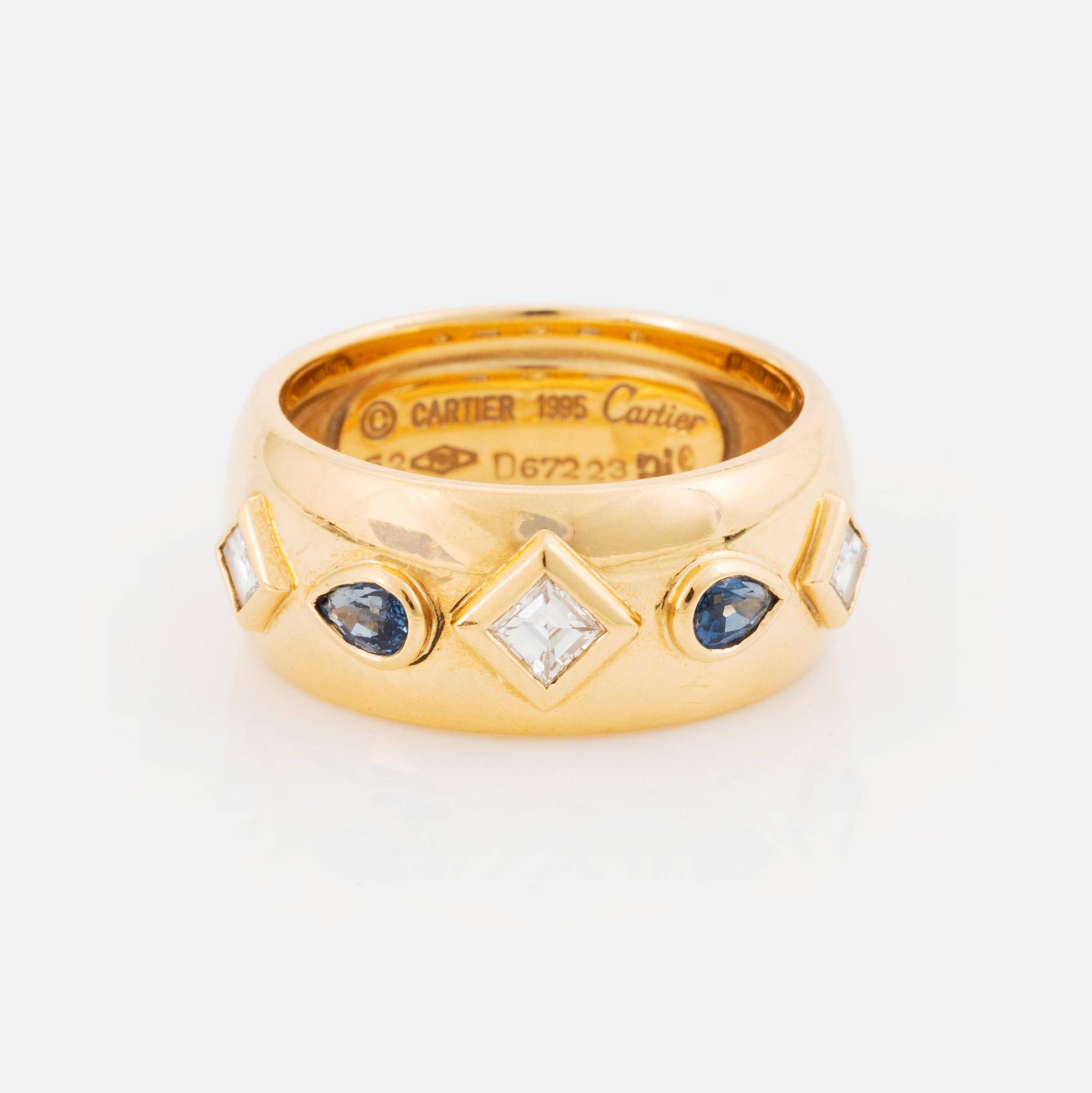 An 18K gold Cartier ring set with step-cut diamonds and faceted sapphires.