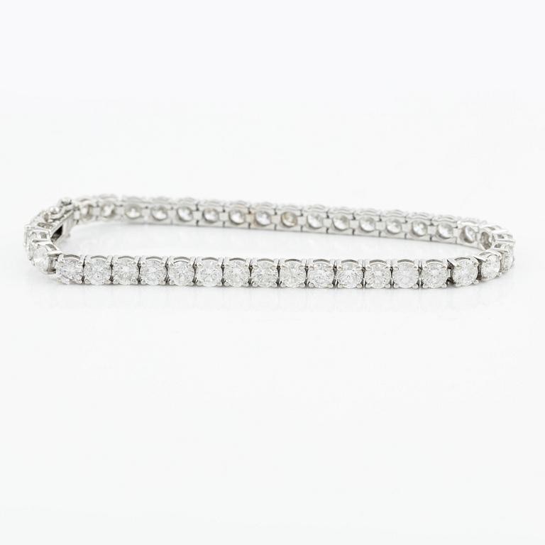 An 18K gold tennis bracelet with round brilliant-cut diamonds.