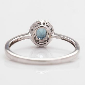 A 14K white gold ring, with small diamonds and an oval-cut sapphire.