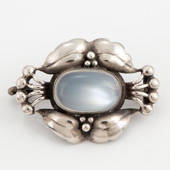 A Georg Jensen silver and cabochon-cut moonstone brooch.