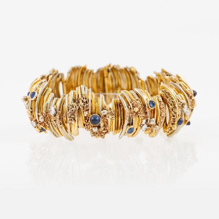 An 18K gold bracelet set with round brilliant-cut diamonds and cabochon-cut sapphires.